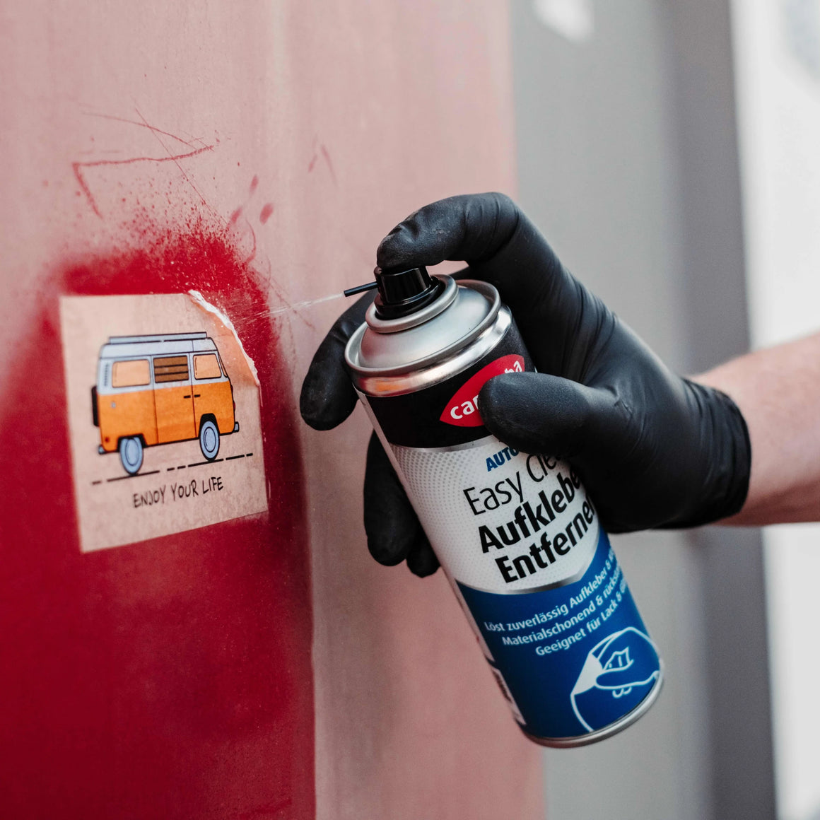 Bild der Anwendung des Caramba Aufkleberentferners an einem Papieraufkleber 