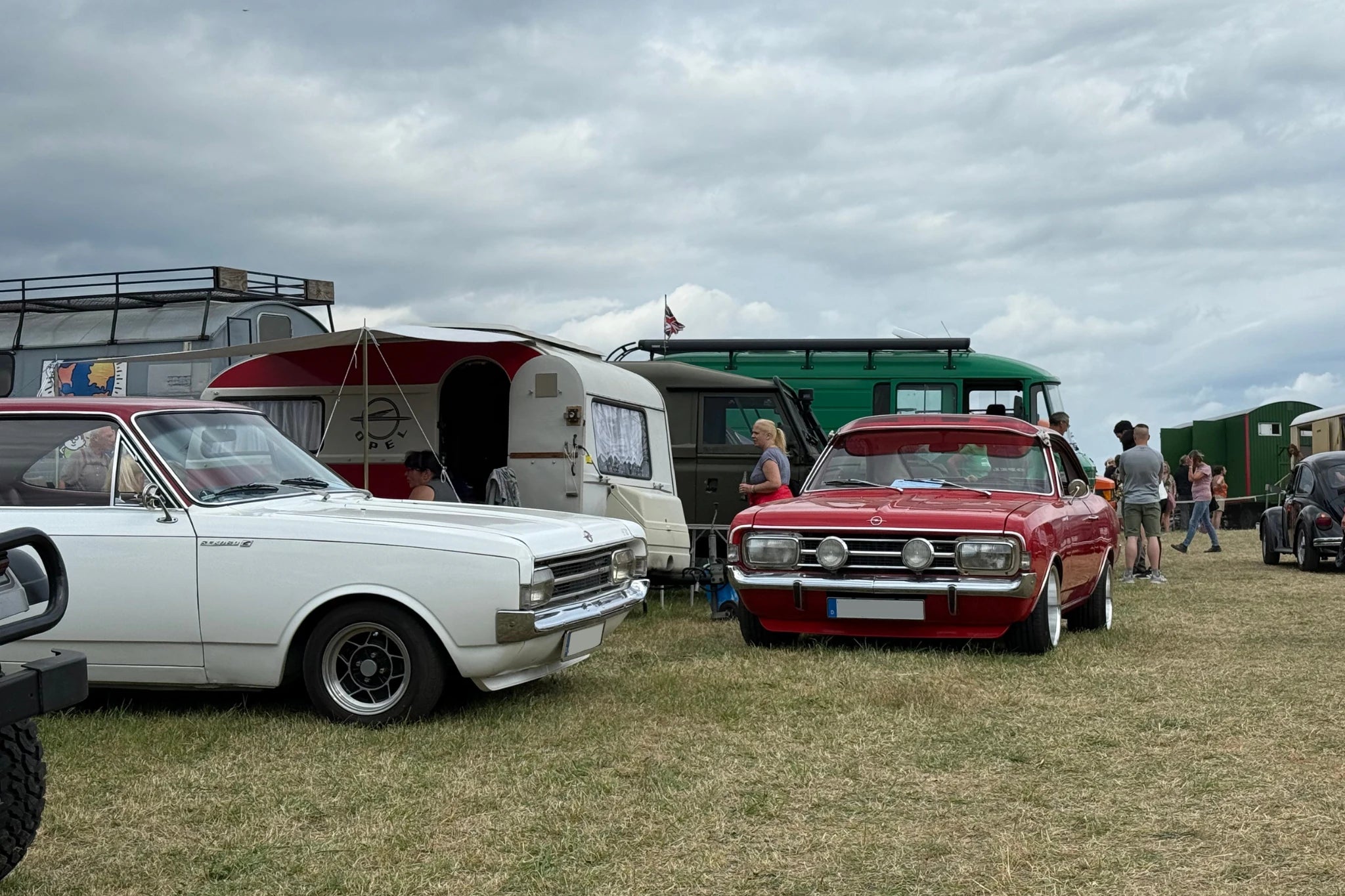 Bild zweier Opel und eines zugehörigen Wohnwagens auf der Wiese eines Oldtimertreffens