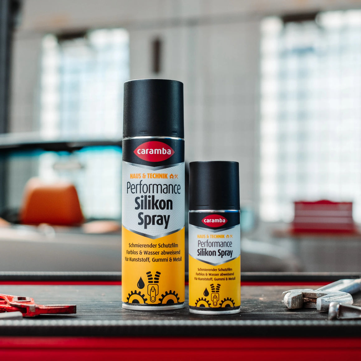 Bild der Frontalansicht einer Dose Caramba Silikonspray auf einer Werkzeugkiste.