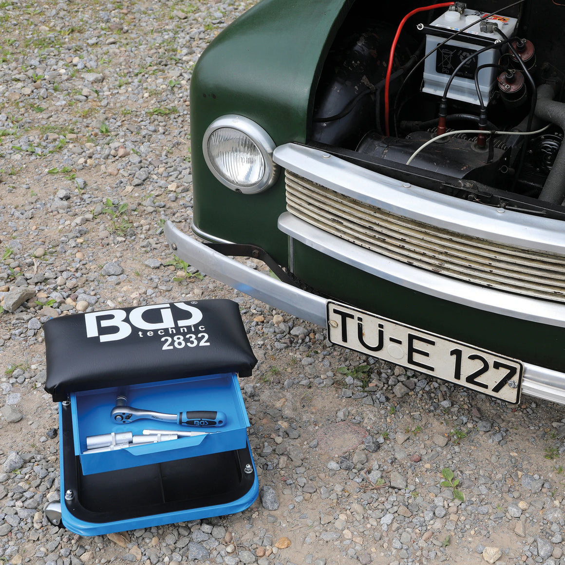 Bild eines Werkstatt-Rollsitzes vor einem Oldtimer fotografiert
