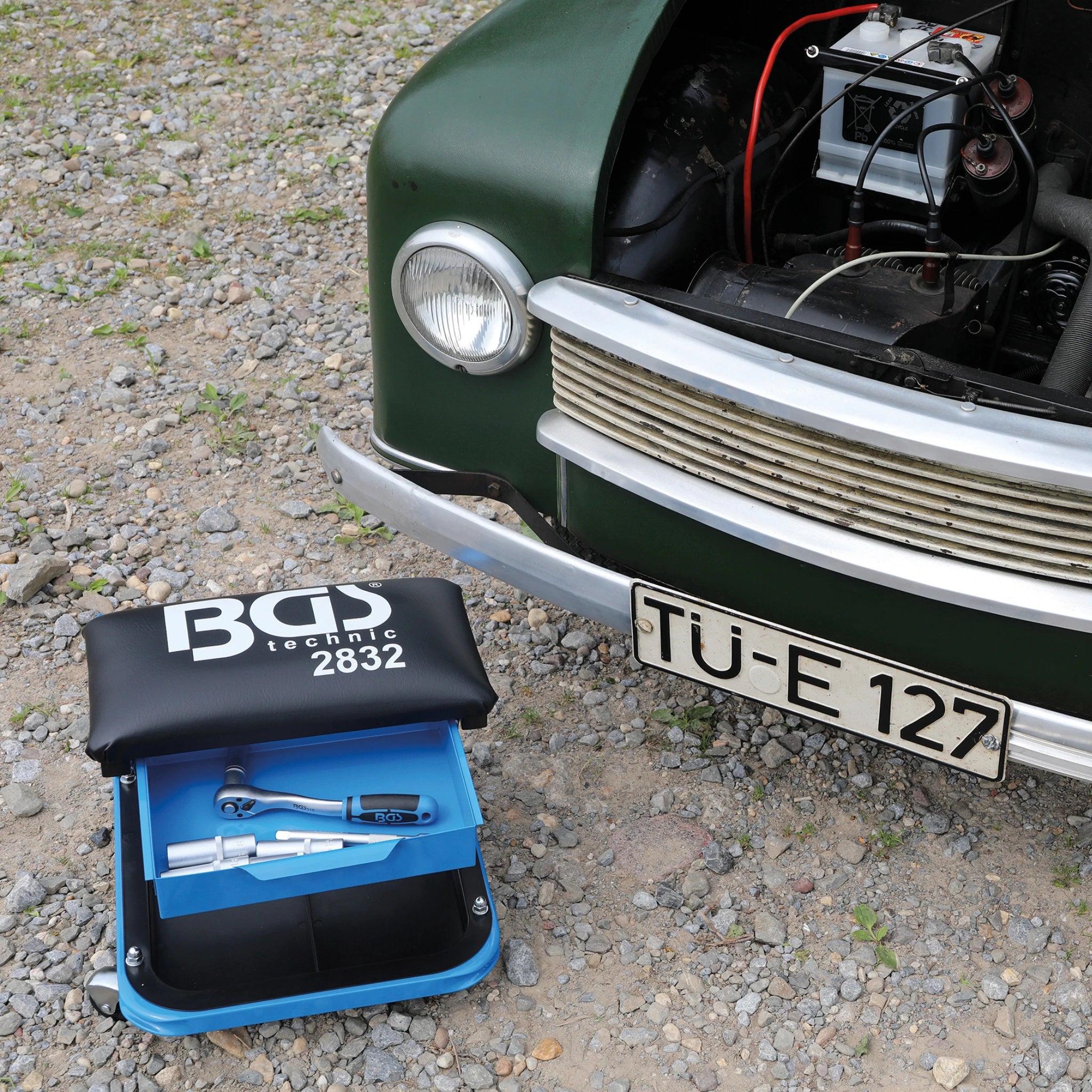 Bild eines Werkstatt-Rollsitzes vor einem Oldtimer fotografiert