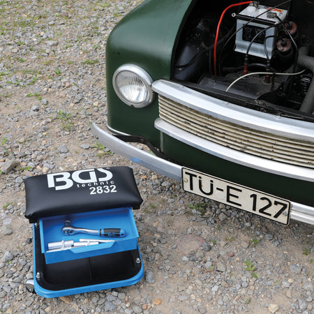 Bild eines Werkstatt-Rollsitzes vor einem Oldtimer fotografiert